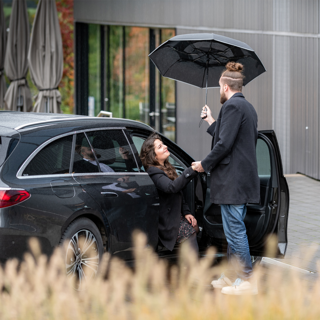 Pocket umbrella Windfighter 2.0 Carbon man and woman by car