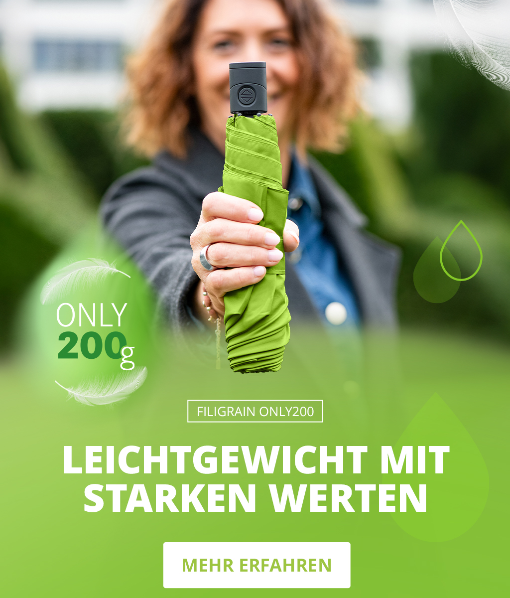 Banner zum FiligRain Only200 Regenschirm: Frau wirft einen leichten grünen Schirm in die Luft, Nahaufnahme eines zusammengefalteten Schirms, umgeben von Wassertropfen und Federn. Text: 'Leichtgewicht mit starken Werten – Only 200g – Mehr erfahren