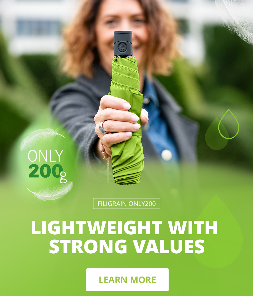 Banner for the FiligRain Only200 umbrella: Woman throwing a lightweight green umbrella into the air, close-up of a folded umbrella, surrounded by water droplets and feathers. Text: 'Lightweight with strong values – Only 200g – Learn more